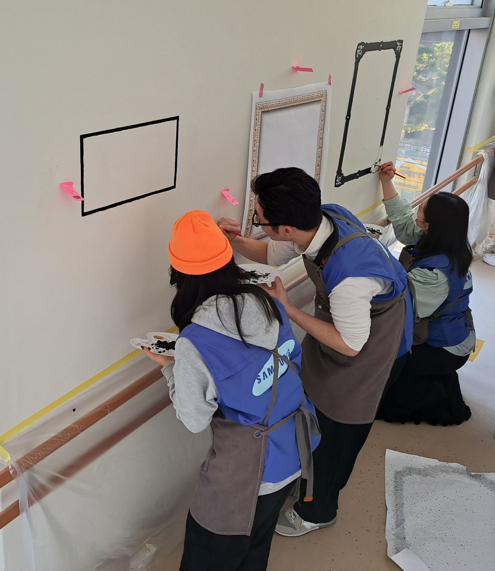 삼성물산 패션부문 임직원들이 벽화그리기 봉사활동을 하는 모습